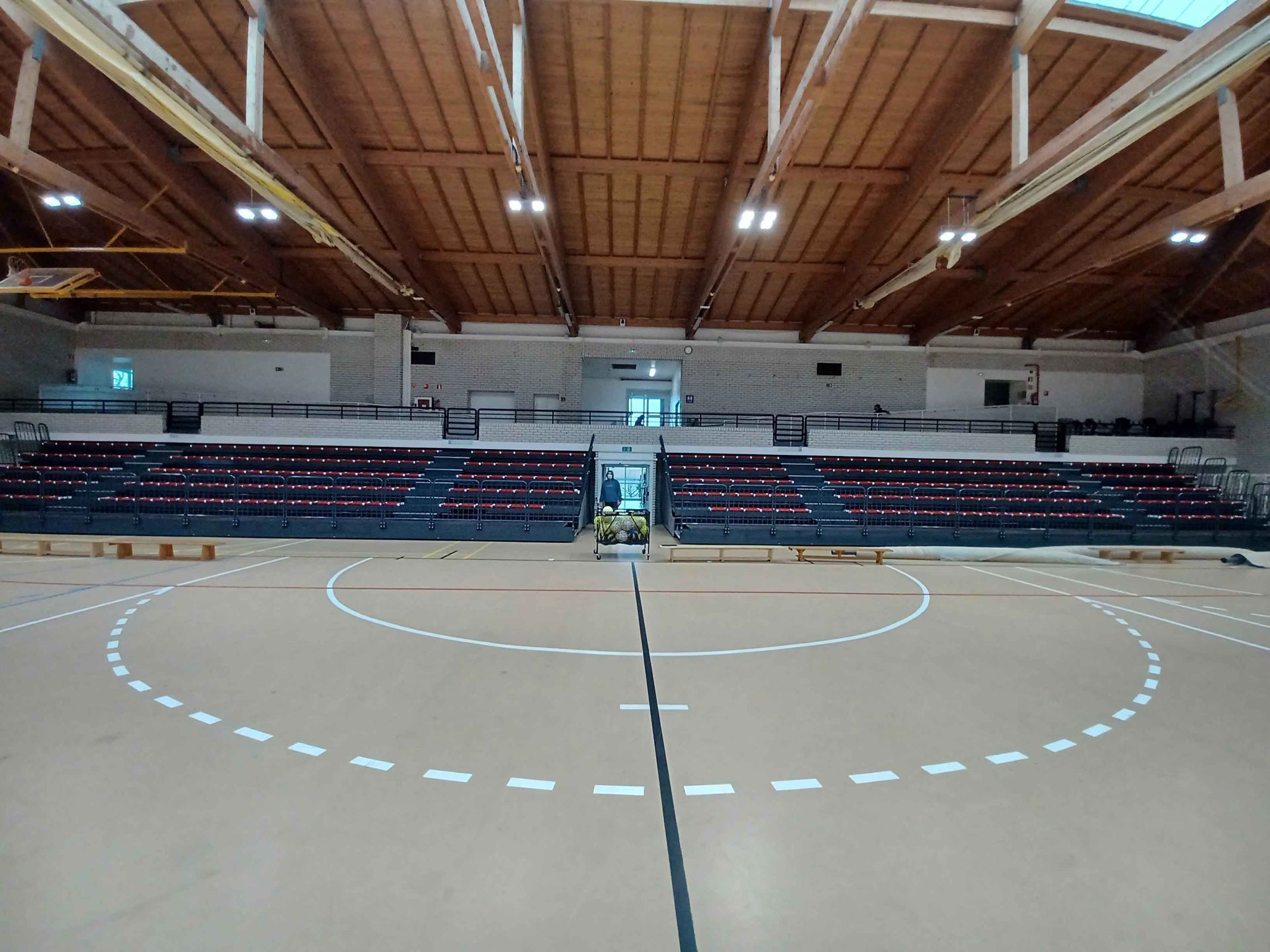 Una cancha de baloncesto dentro de un edificio con techo de madera.
