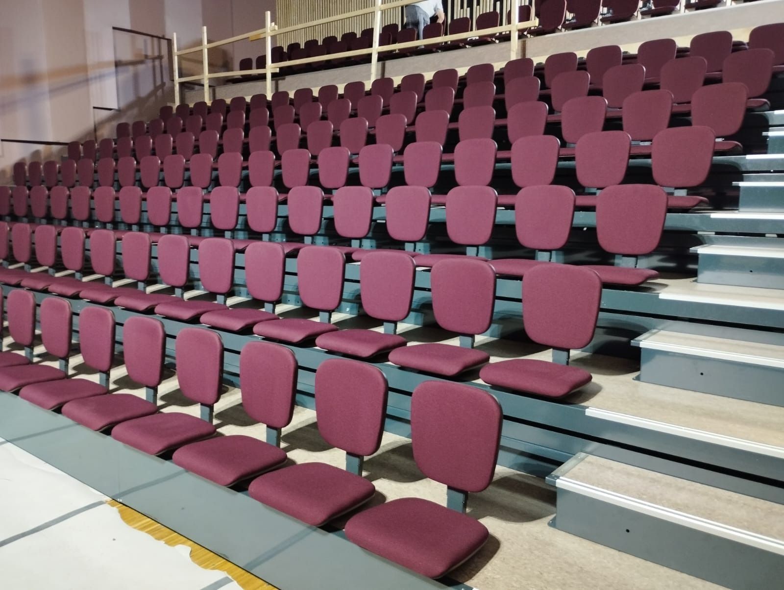 Filas de asientos rojos en un estadio con escaleras