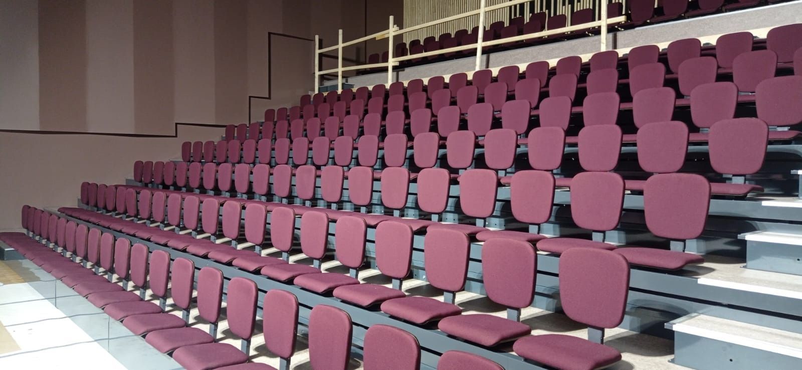 Una fila de sillas moradas están alineadas en un estadio.