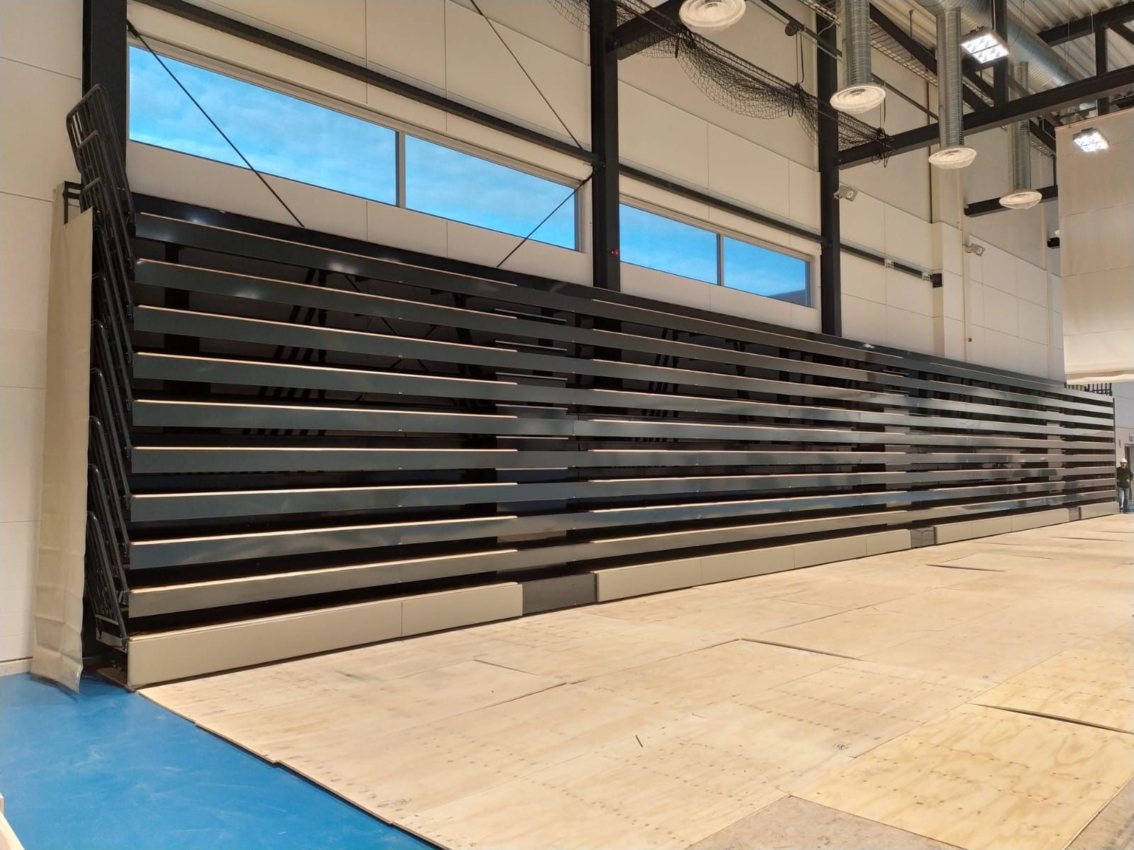 Una fila de gradas en un gimnasio con suelo azul.