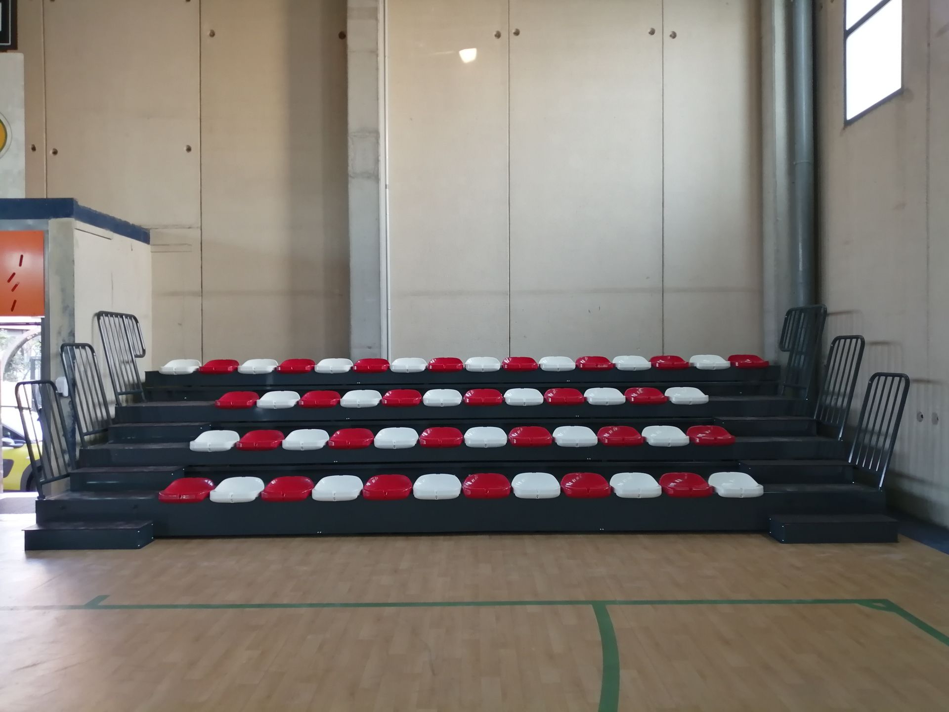 Una fila de asientos rojos, blancos y azules en un gimnasio.