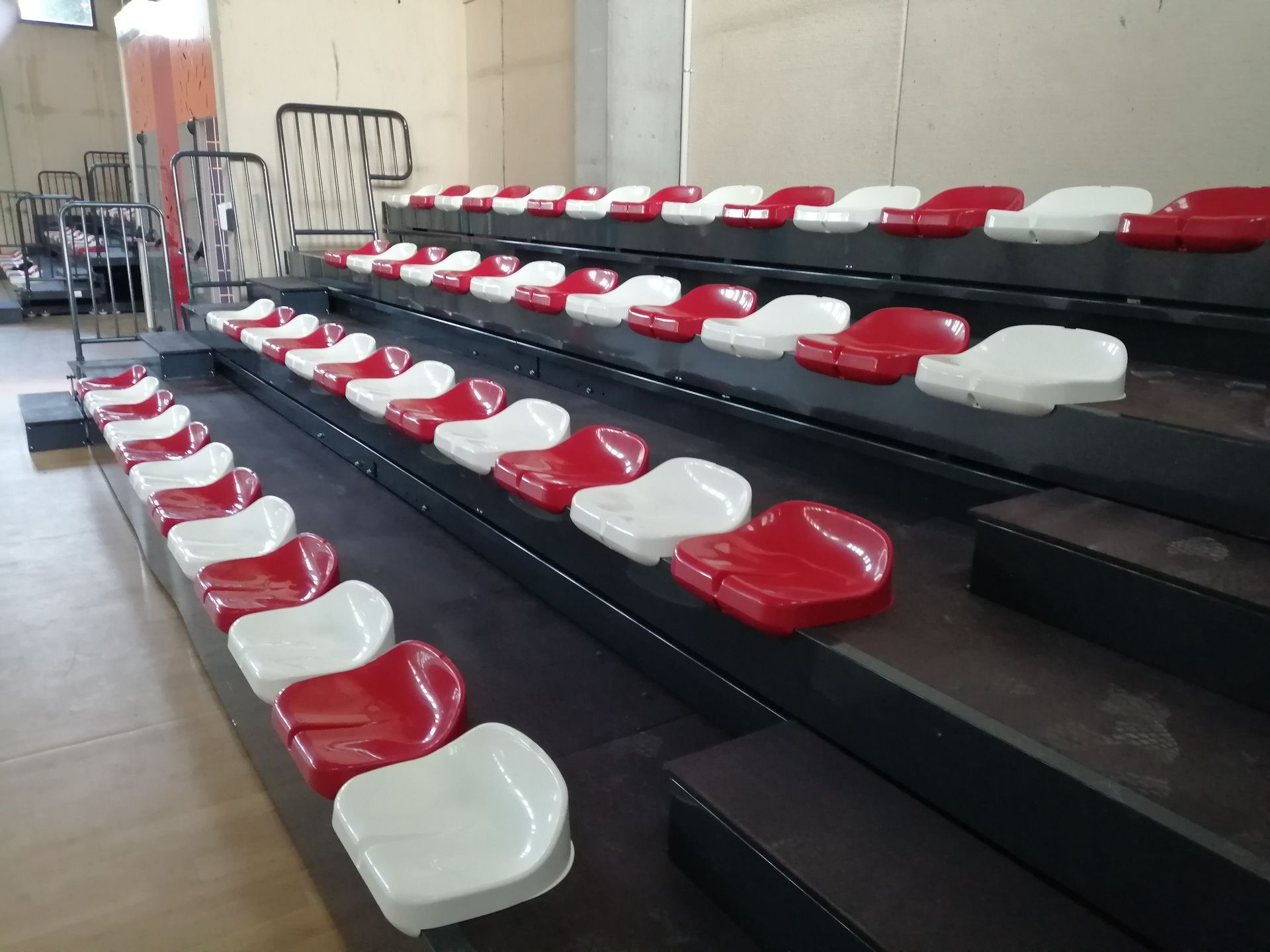 Una fila de asientos rojos y blancos en un estadio