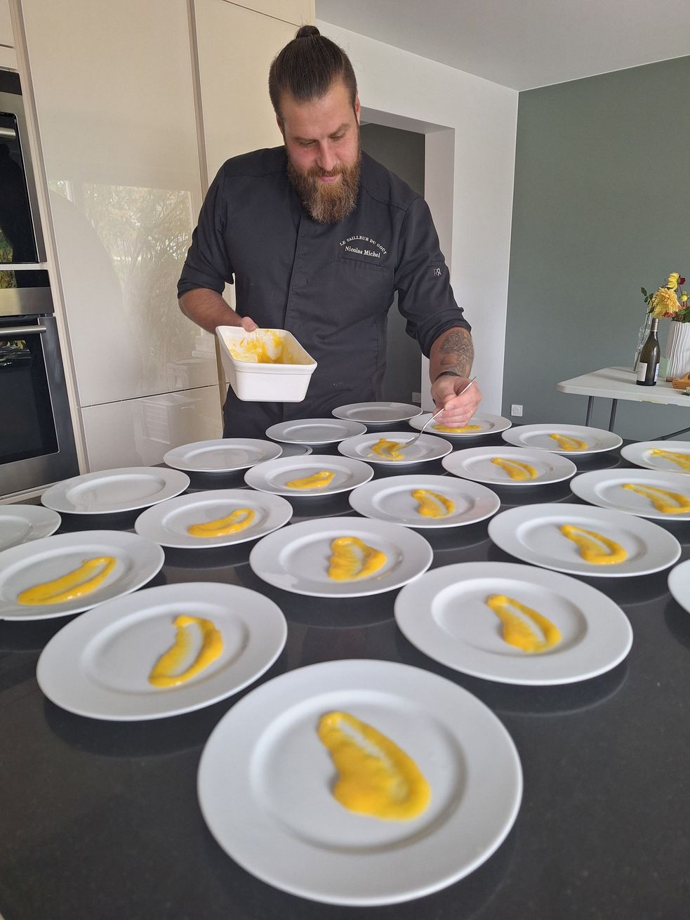 Vendeur ambulant préparant des plats sur un stand en plein air, avec des petits pains, de la sauce, des légumes et des ingrédients dans des contenants