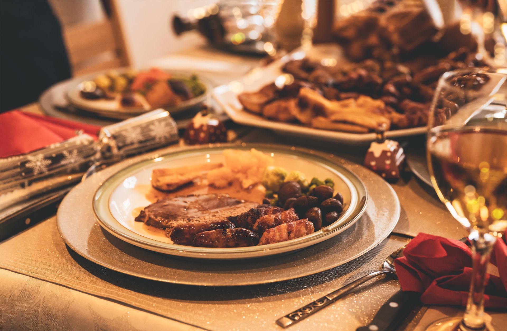 Élégante table de fête avec rôti servi à l’assiette, verres à vin et décorations festives
