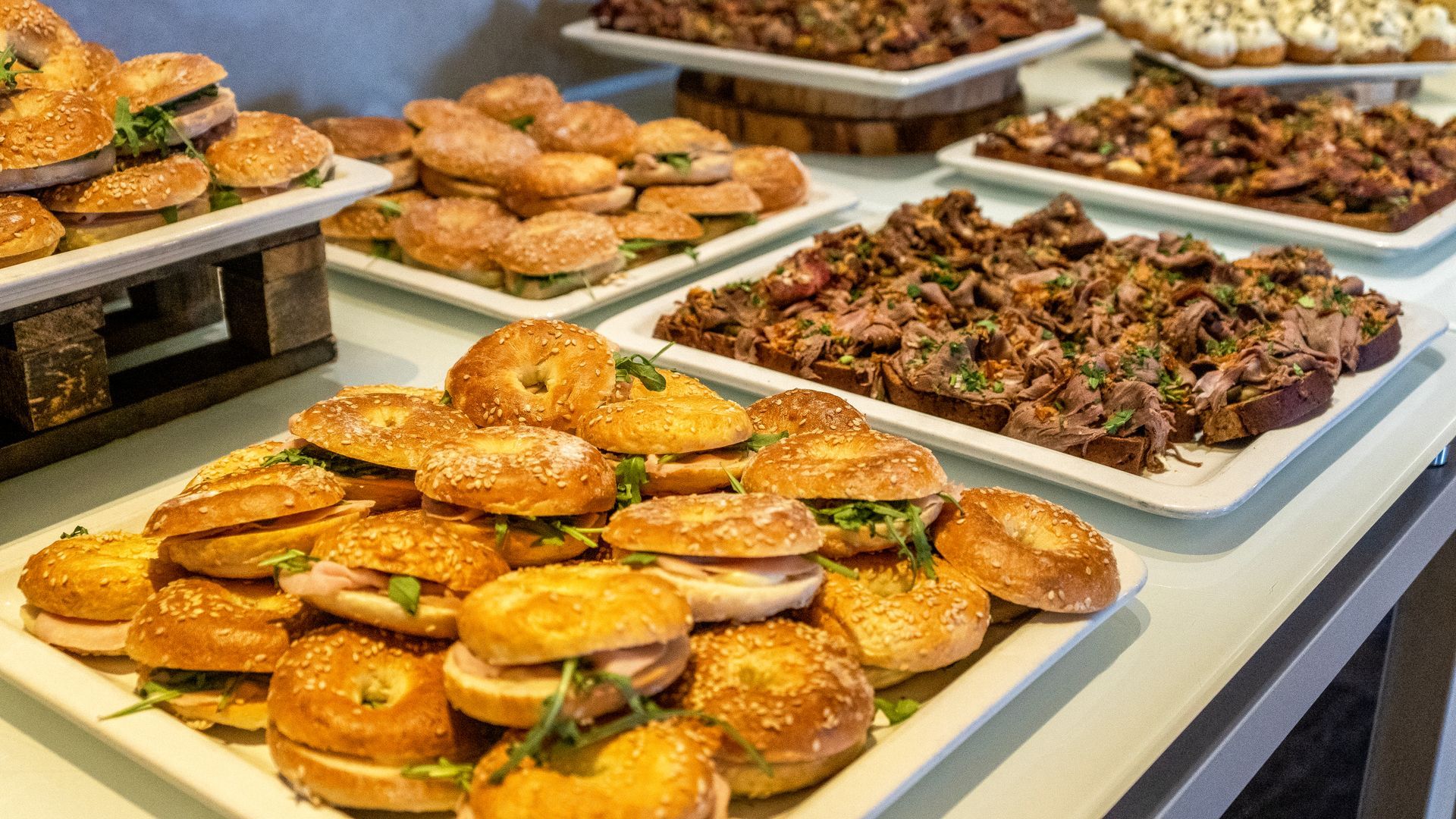 Plateaux de pâtisseries assorties et de sandwichs salés présentés sur un buffet