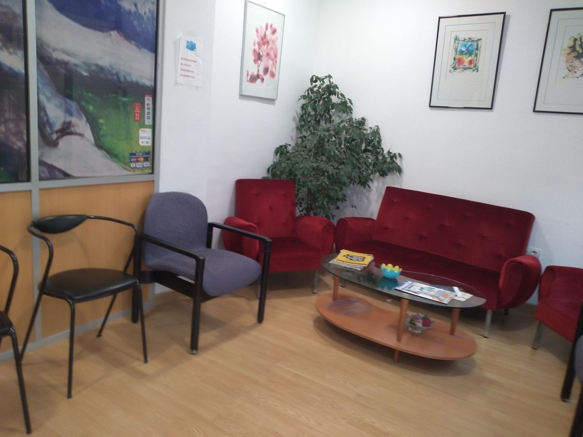 Una sala de espera con sillas, un sofá y una mesa de café.