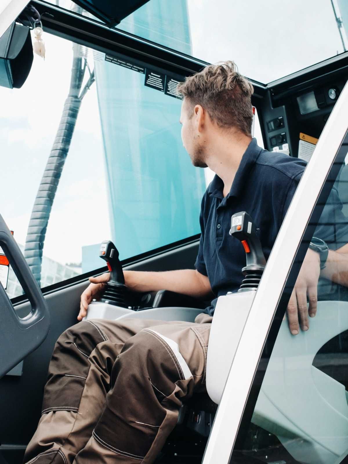 Un hombre está sentado en el asiento del conductor de un camión.