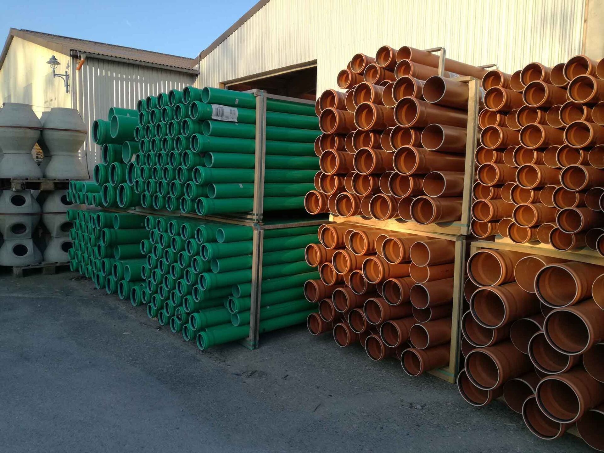 Auf einem Lagerplatz türmen sich grüne und braune Rohre