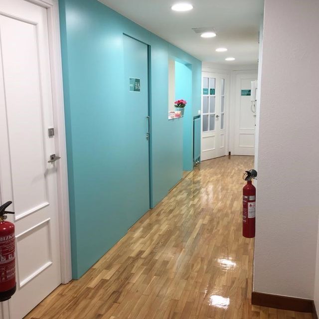 Un pasillo con un extintor de incendios en la esquina.