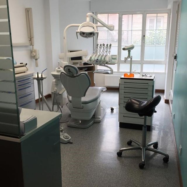 Un consultorio dental con una silla y una ventana.