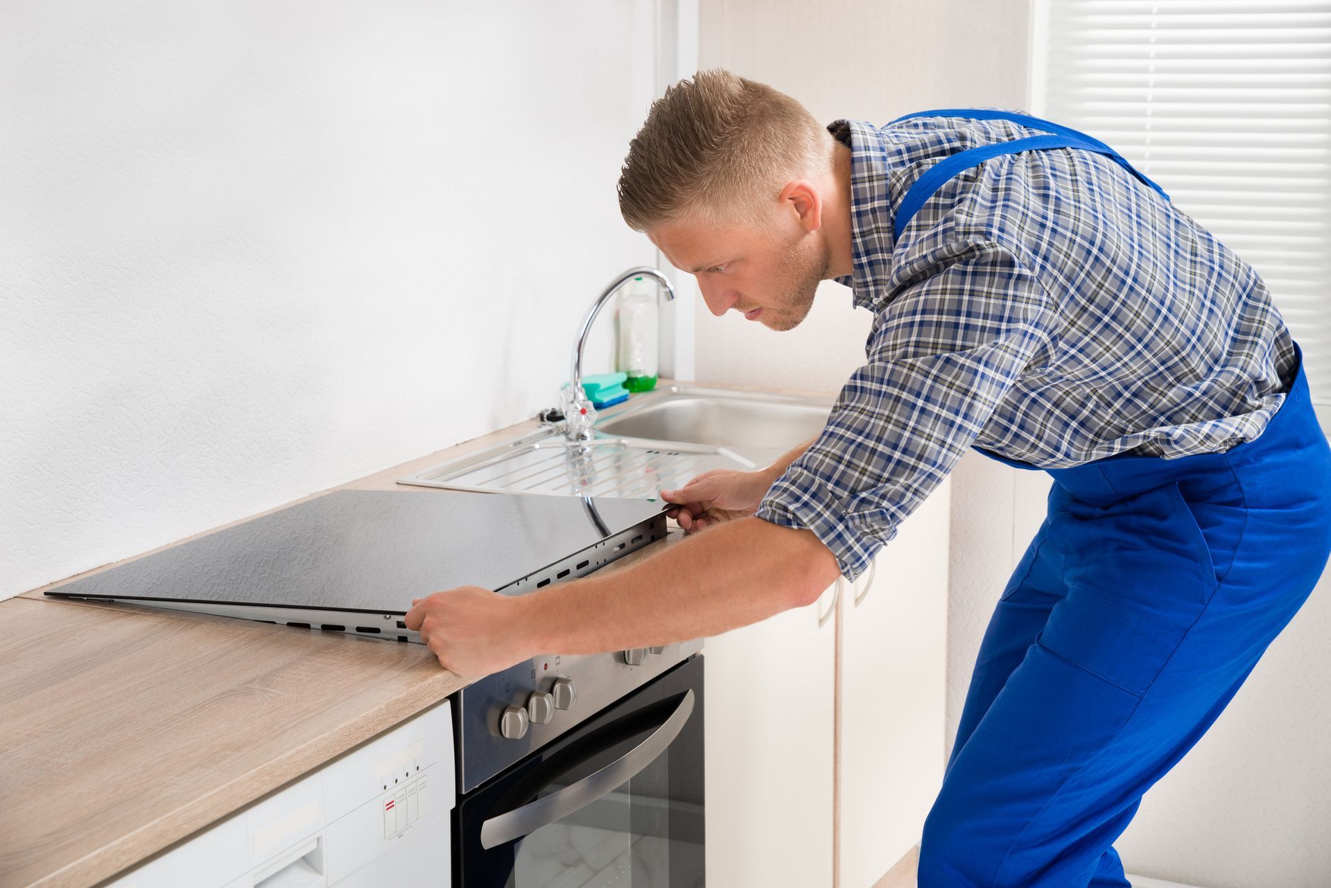 Un hombre está instalando un horno en una cocina.