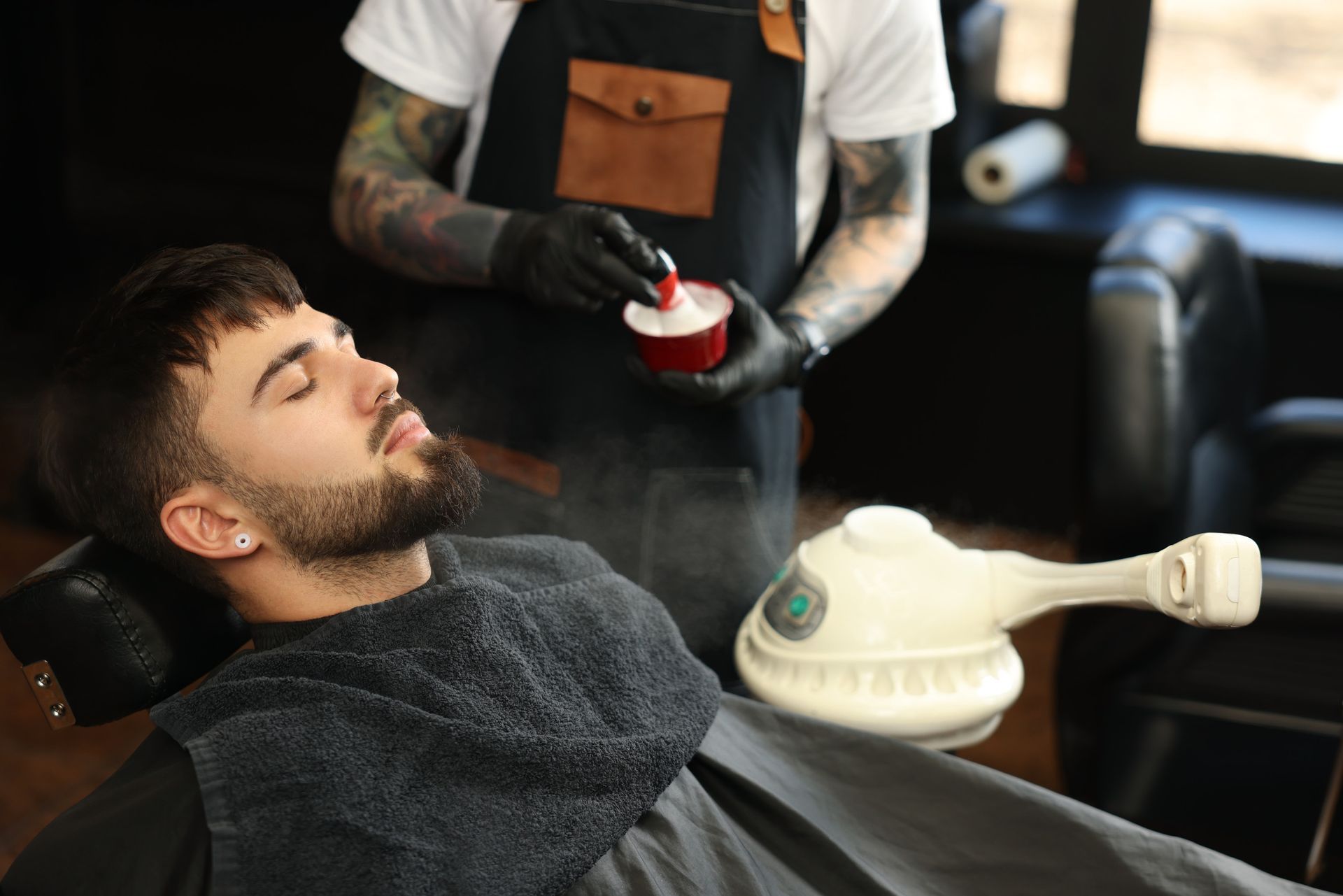 Un hombre se está afeitando en una barbería.