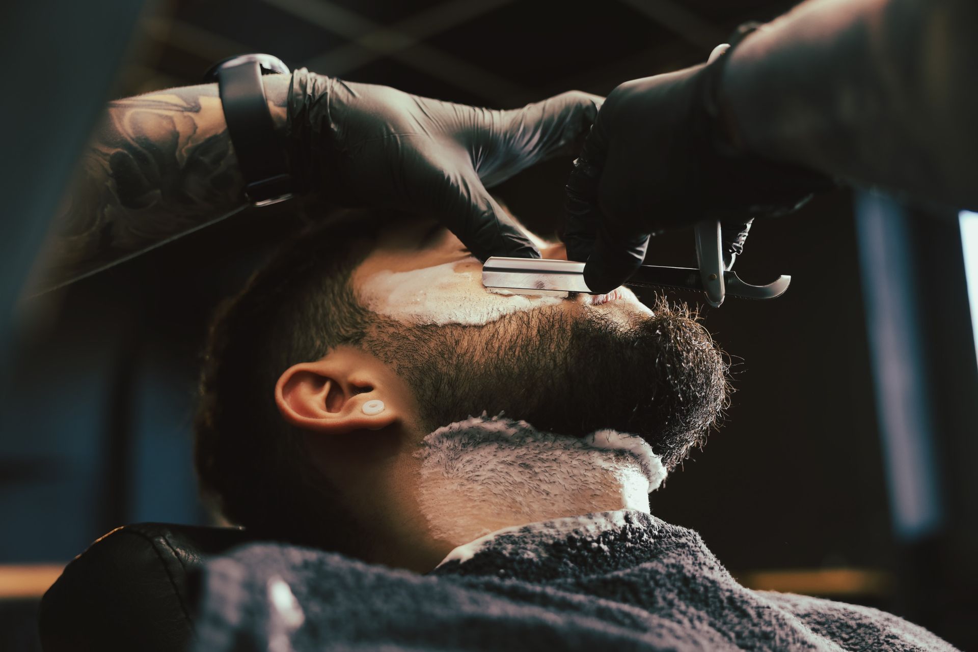 Un hombre se está afeitando la barba con un barbero.