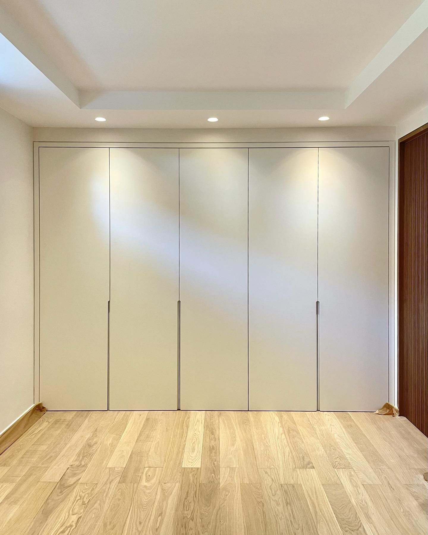 Una habitación vacía con paredes blancas y suelos de madera.