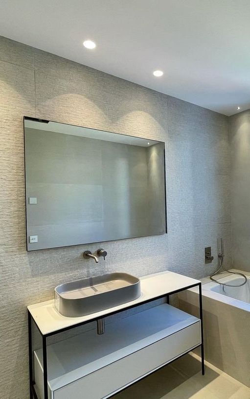 Un baño con lavabo, espejo y bañera.