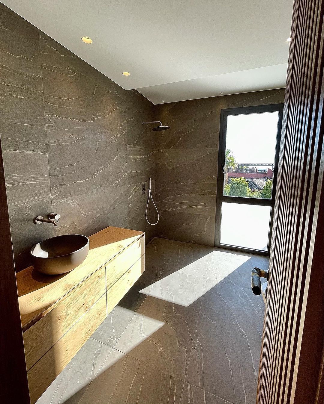 Un baño con lavabo y una gran ventana.