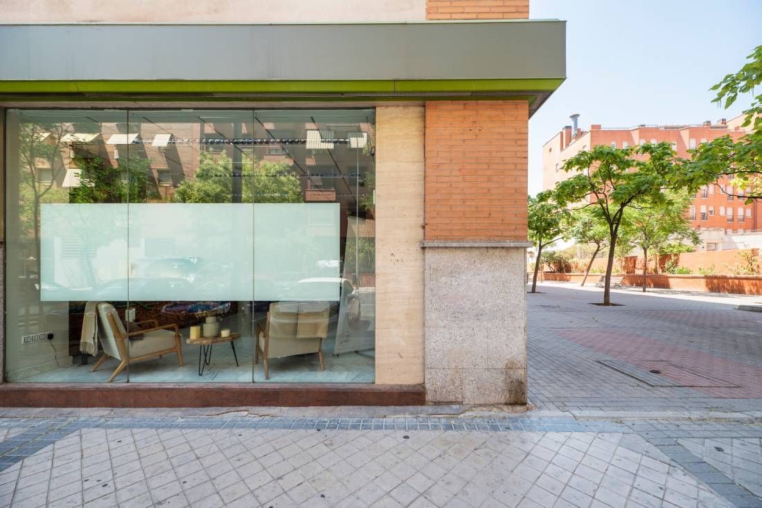 Un escaparate con un gran ventanal y un edificio de ladrillo al fondo.