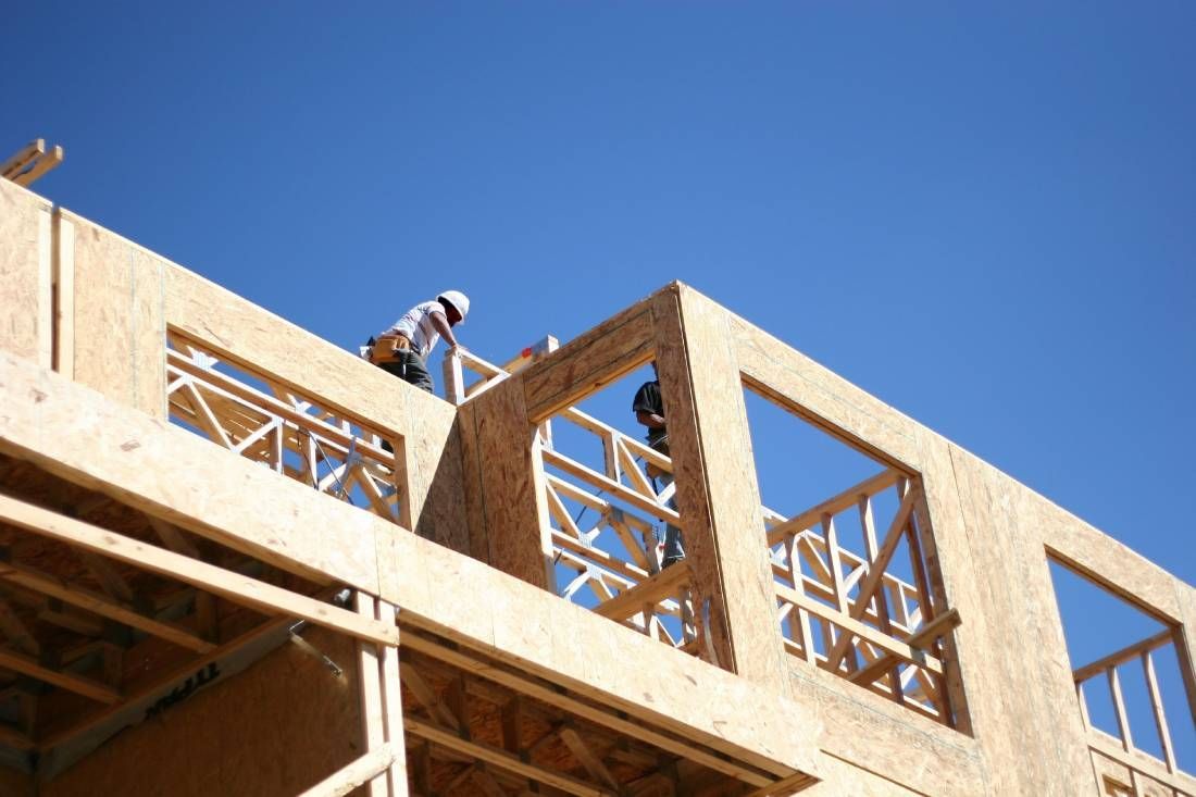 Un hombre está trabajando en el tejado de un edificio en construcción.