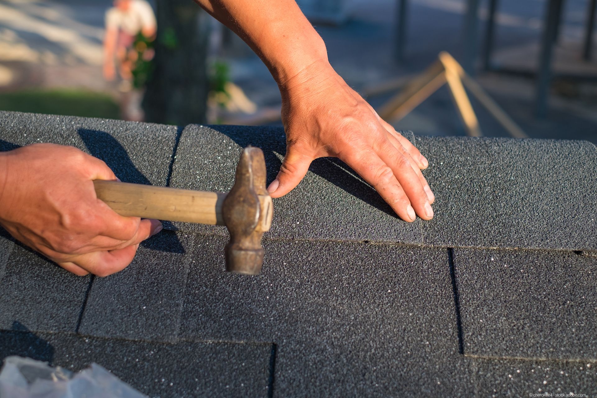 Dachdecker befestigt Ziegel an einem Dach