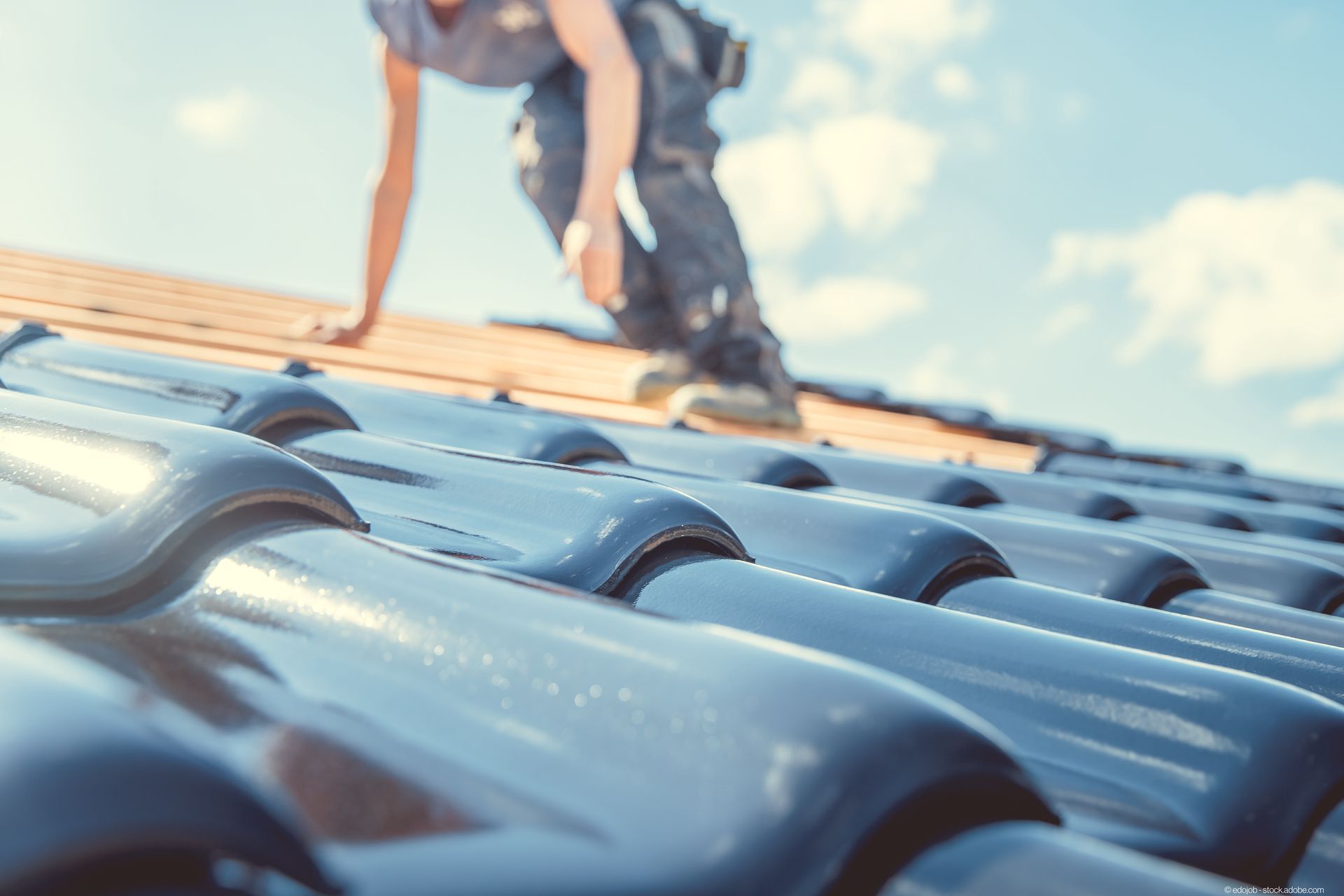 Dachdecker befestigt Ziegel an einem Dach