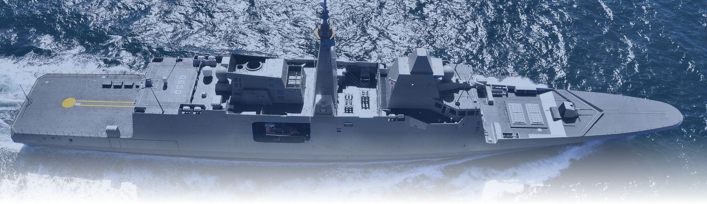 Vue aérienne d'un navire de guerre gris naviguant dans une eau bleue agitée