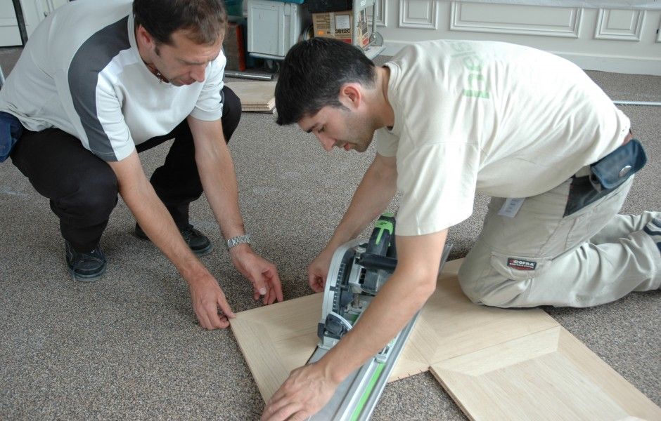 deux hommes poncent un parquet