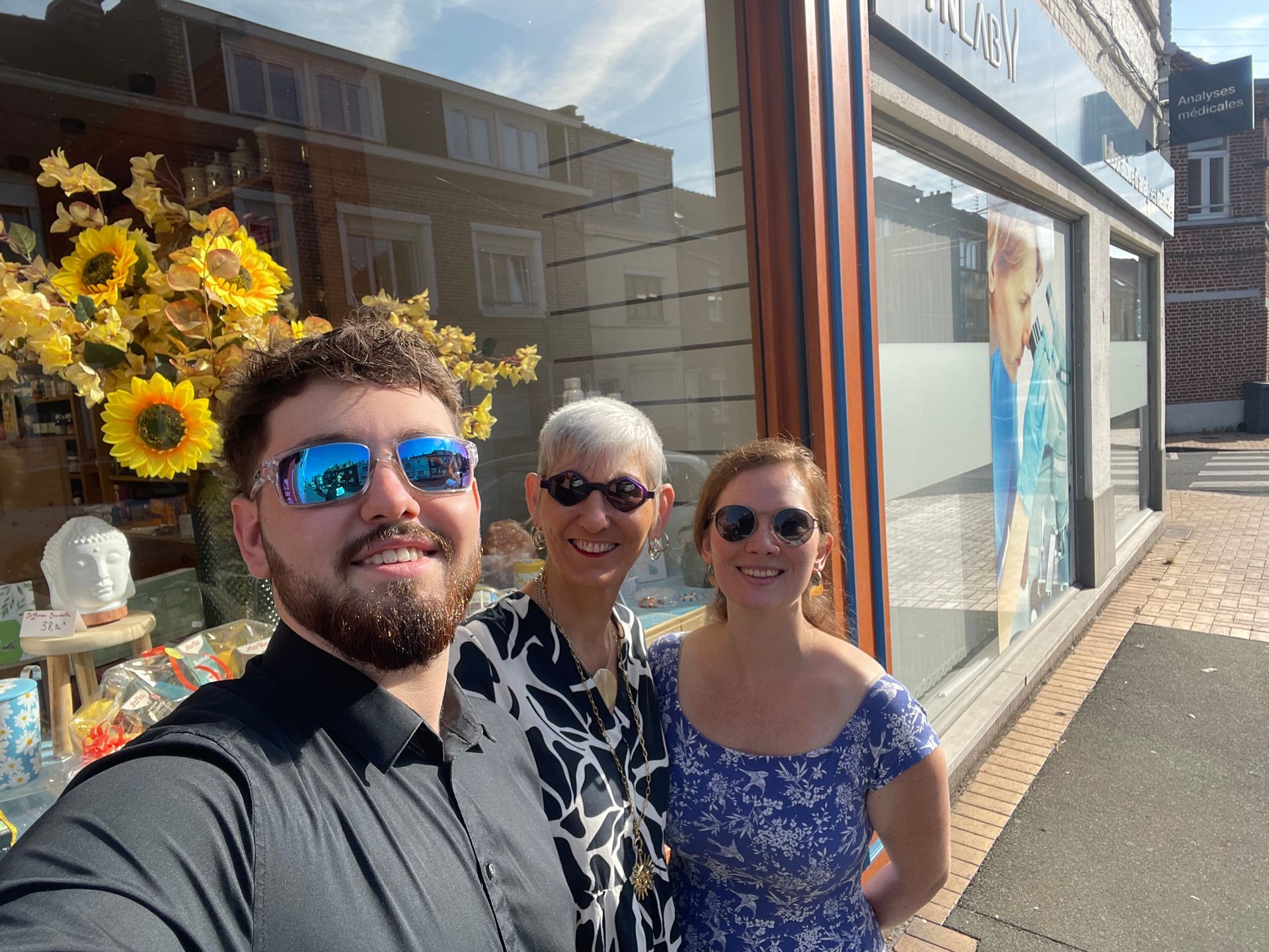Alban, Héloise et Claudie prenant une photo devant le magasin