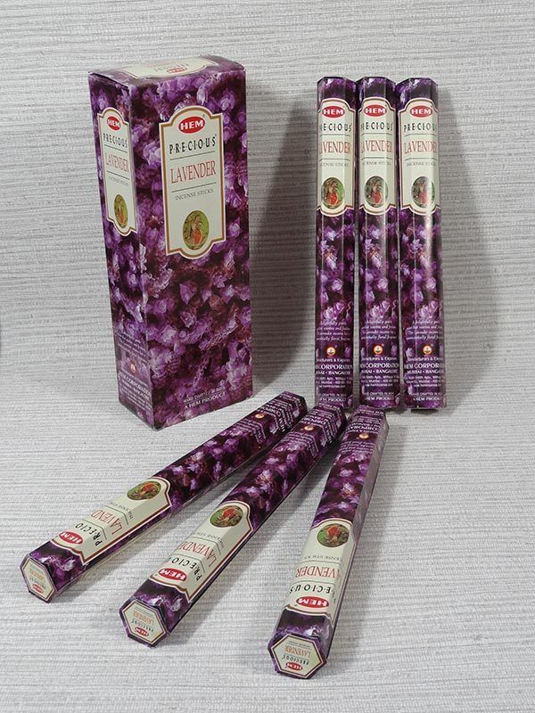 Bâtonnets d'encens violets et boîte assortie disposés sur fond blanc