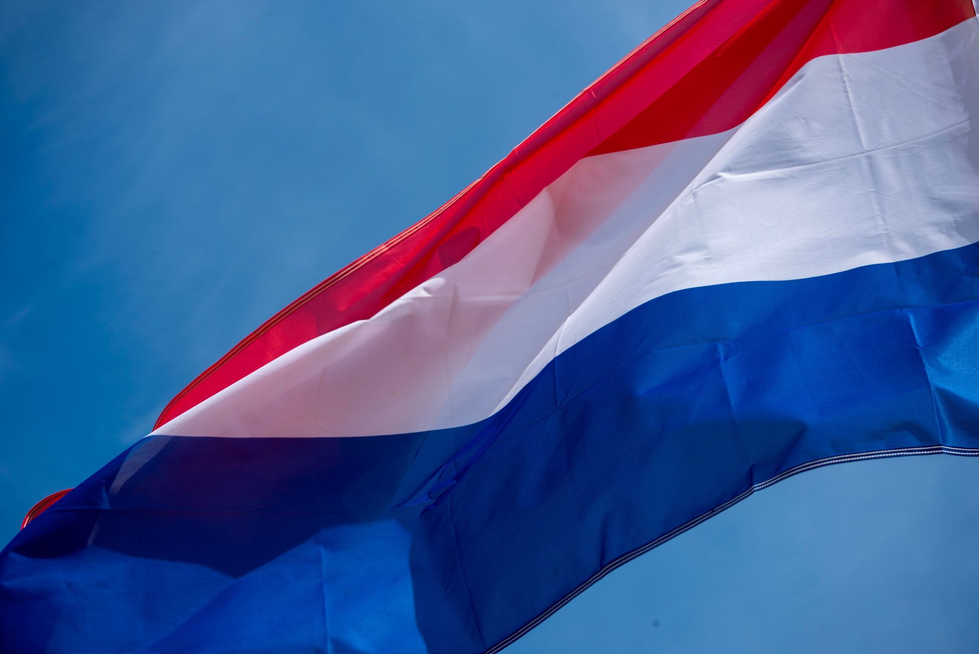 Drapeau néerlandais flottant sur un ciel bleu