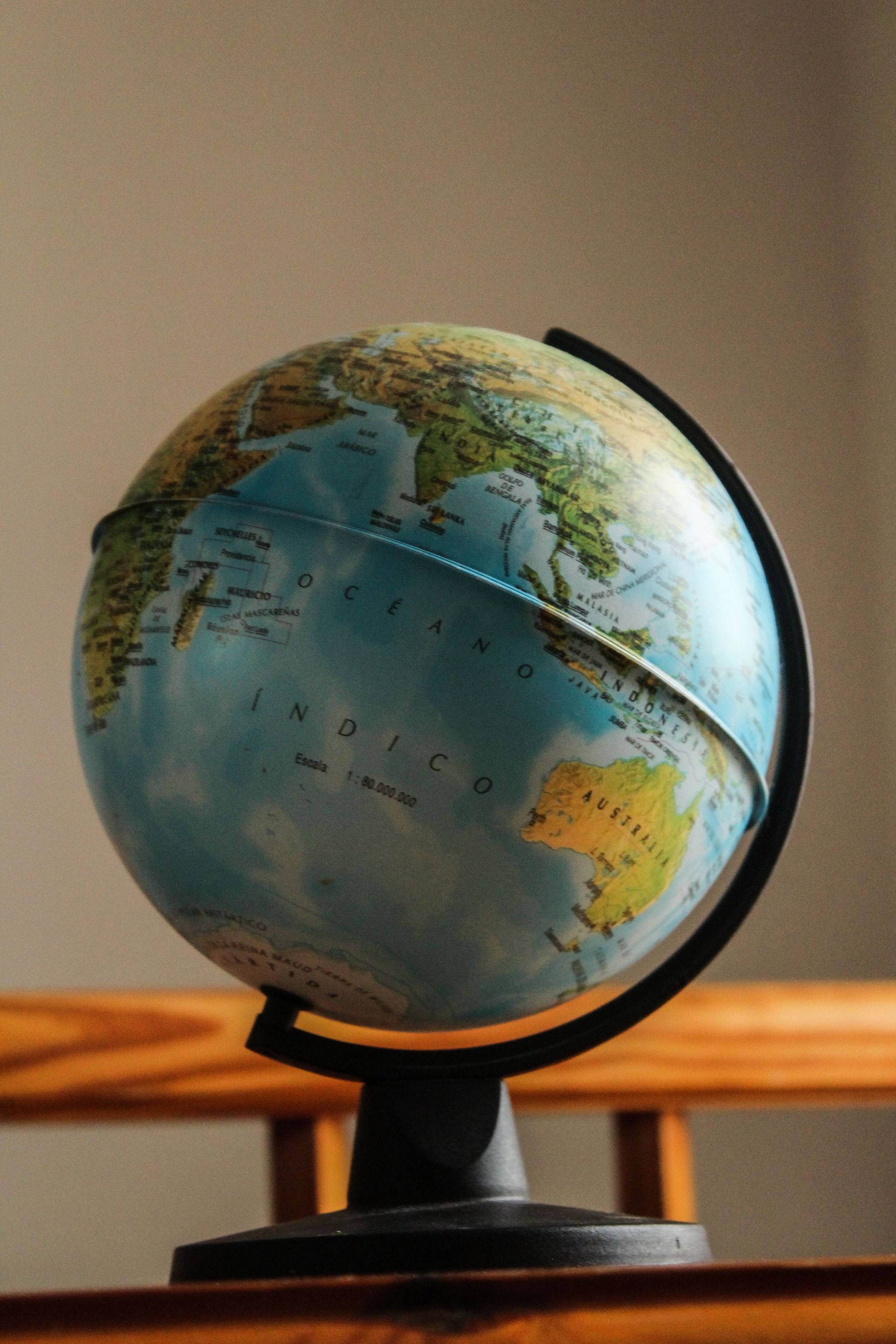 Globe terrestre de bureau sur un support noir, montrant l'Afrique et l'Atlantique sur un fond intérieur chaleureux