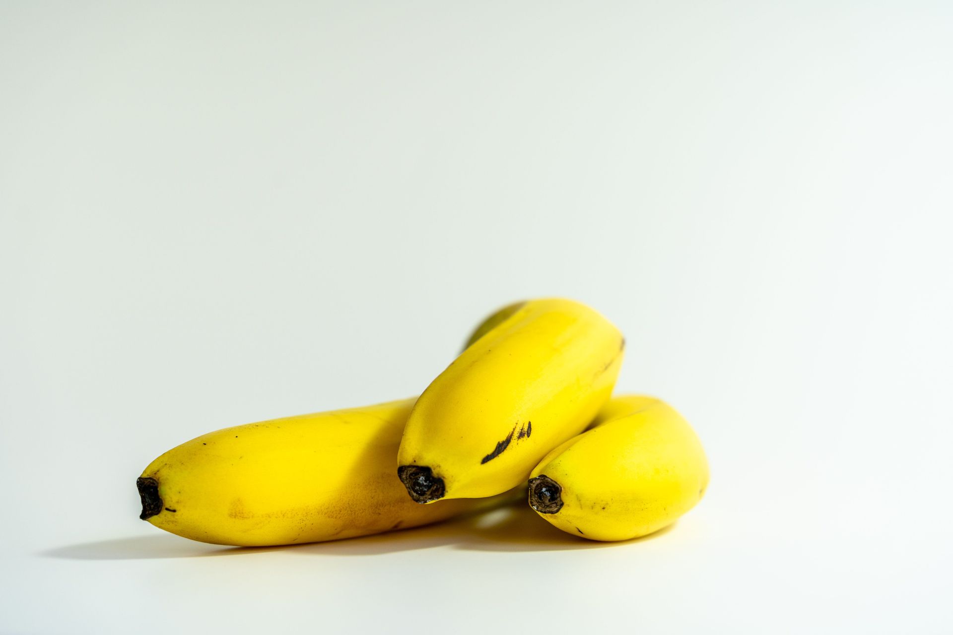 Trois bananes jaunes sur fond blanc