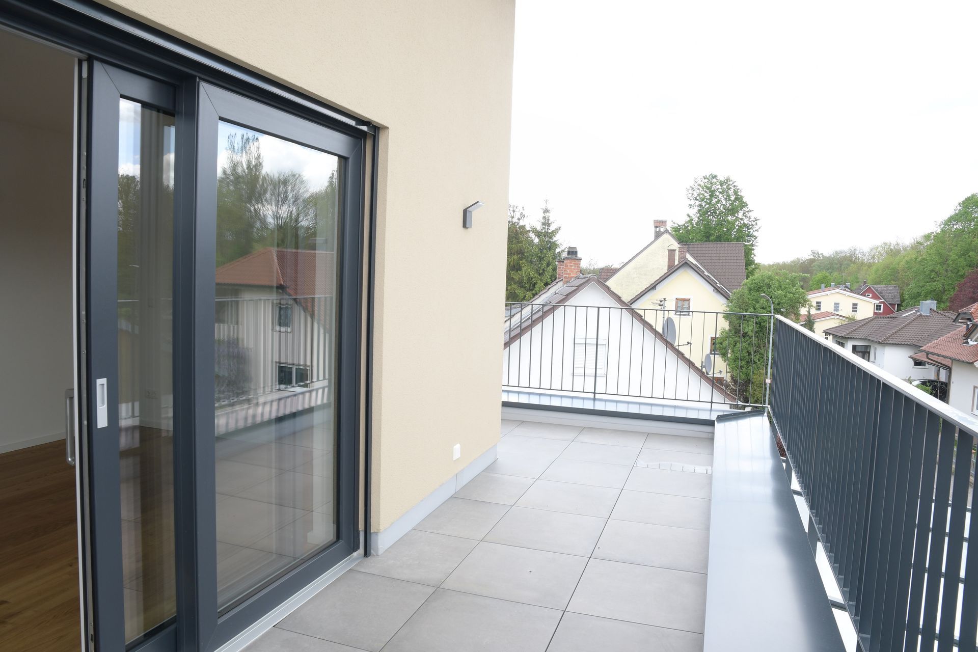 Ein Balkon mit Glasschiebetüren und Blick auf die Stadt.