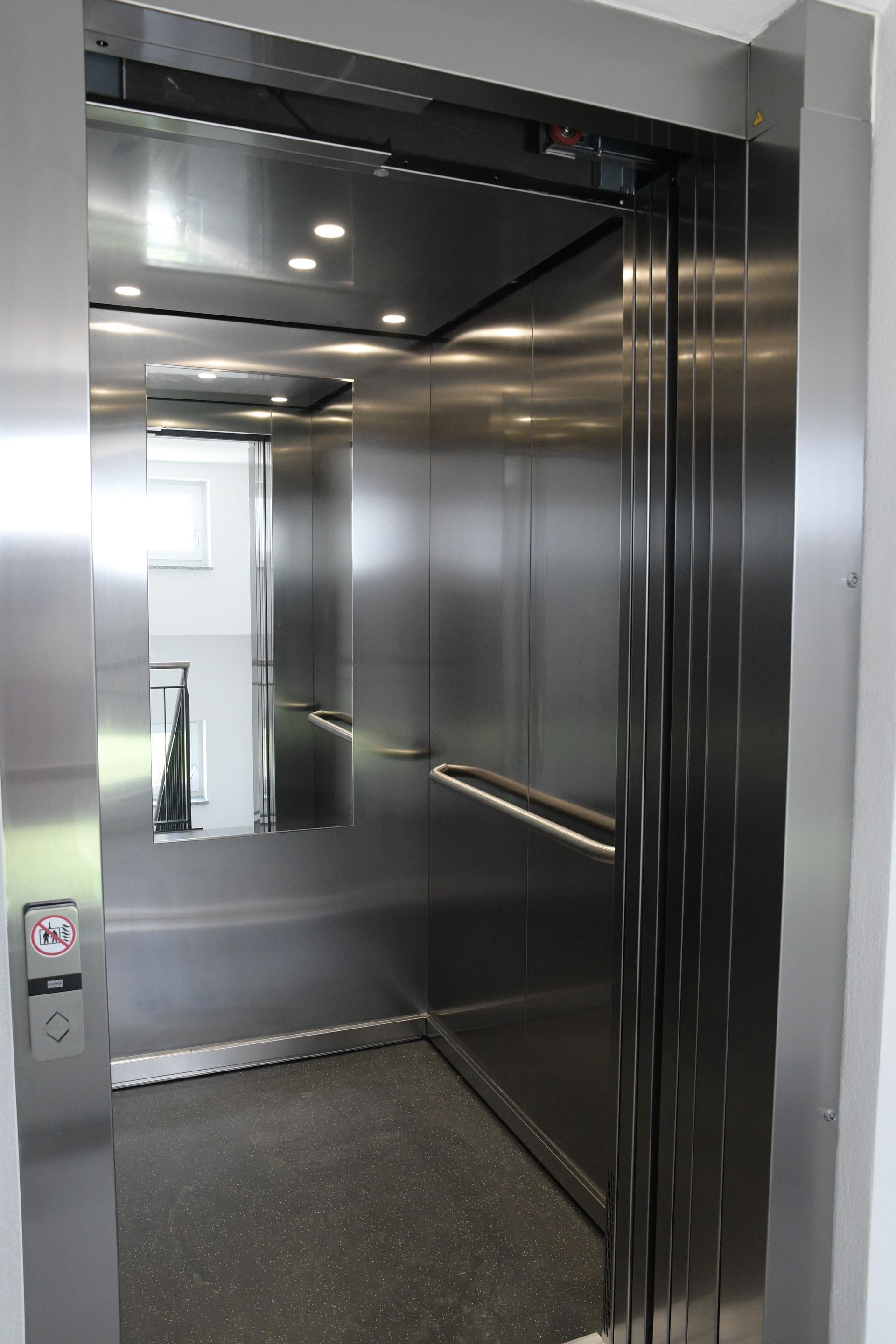 Das Innere eines Edelstahlaufzugs mit geöffneter Tür.