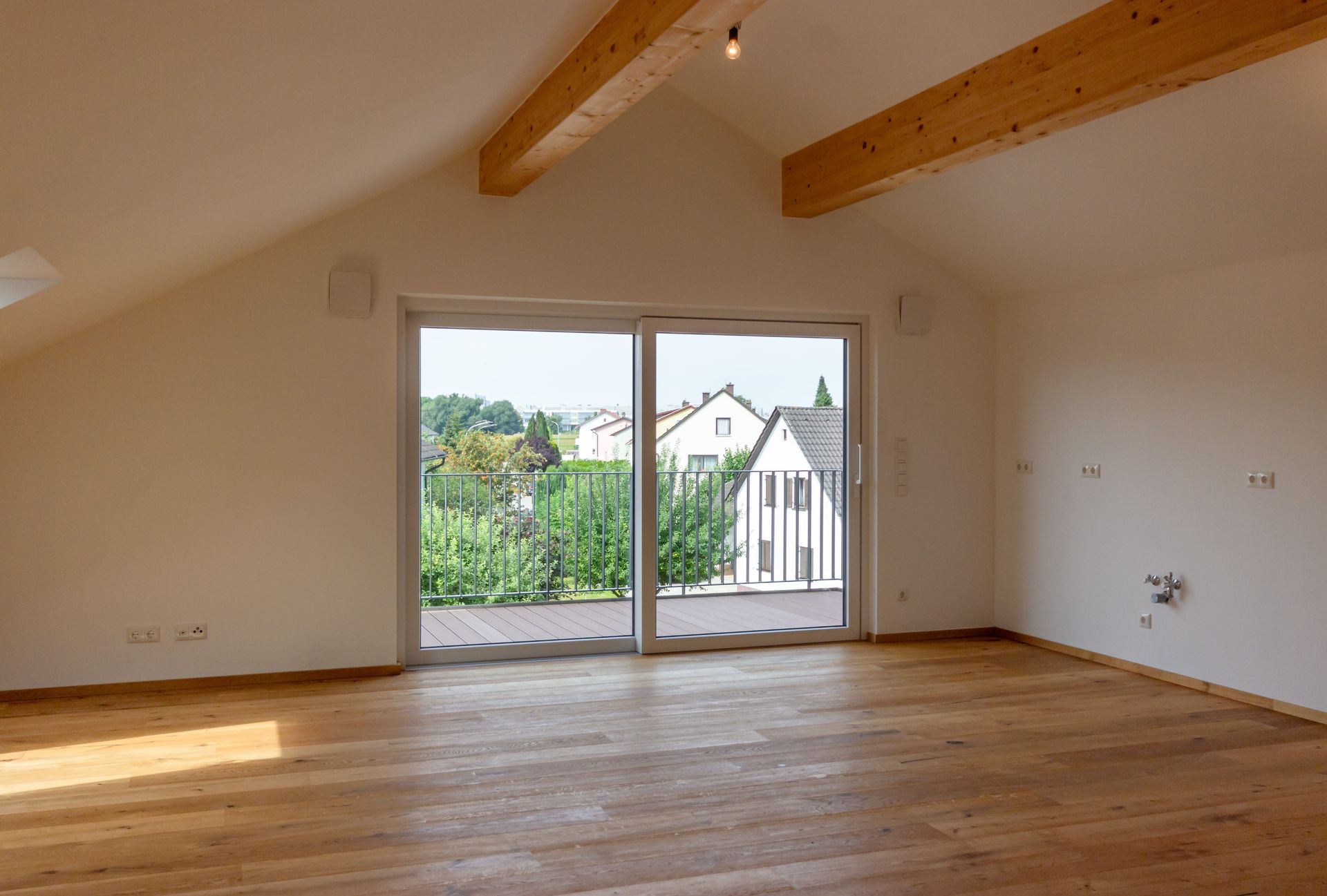 Ein leerer Raum mit einer Glasschiebetür und Holzboden.