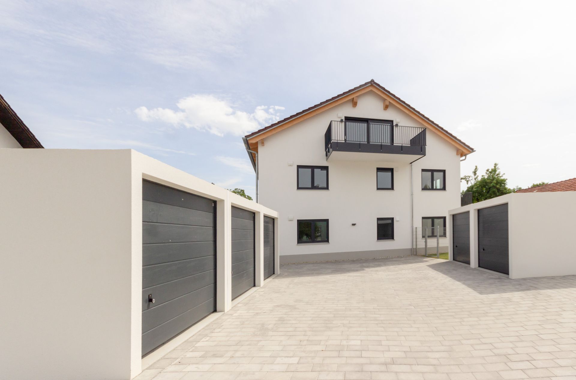 Ein weißes Haus mit vielen Garagen davor.