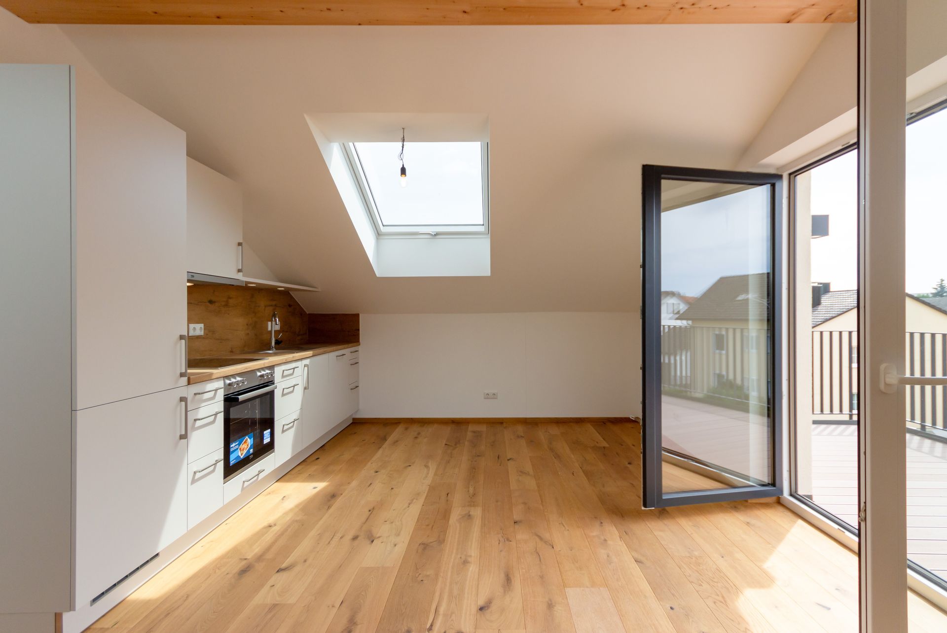 Eine leere Küche mit Hartholzböden und einem Oberlicht.