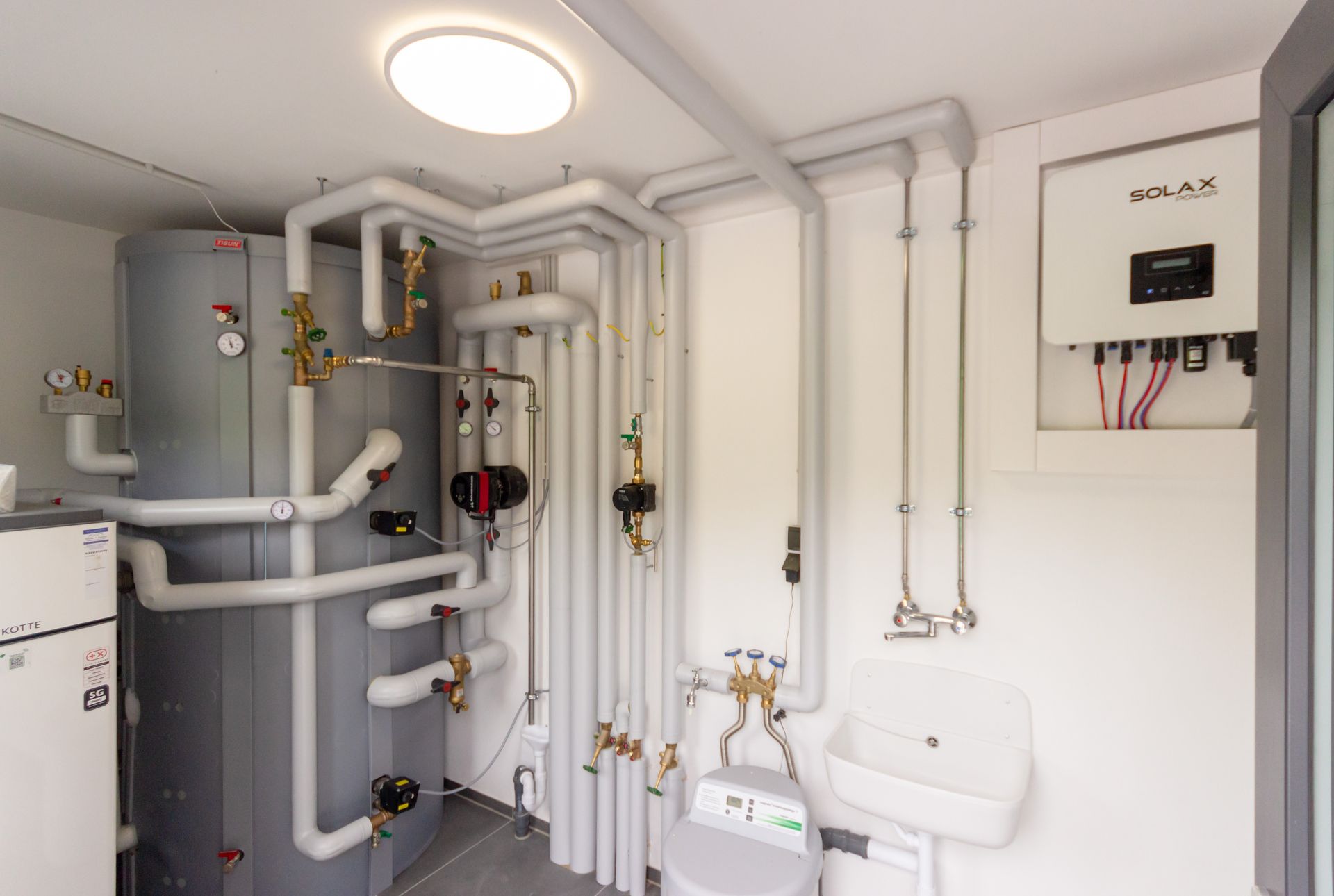 Ein Raum mit vielen Rohren und einem Waschbecken.