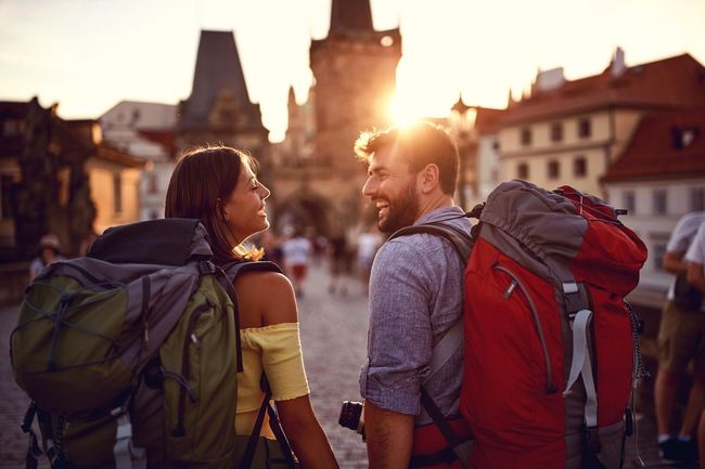 Un hombre y una mujer con mochilas se miran.