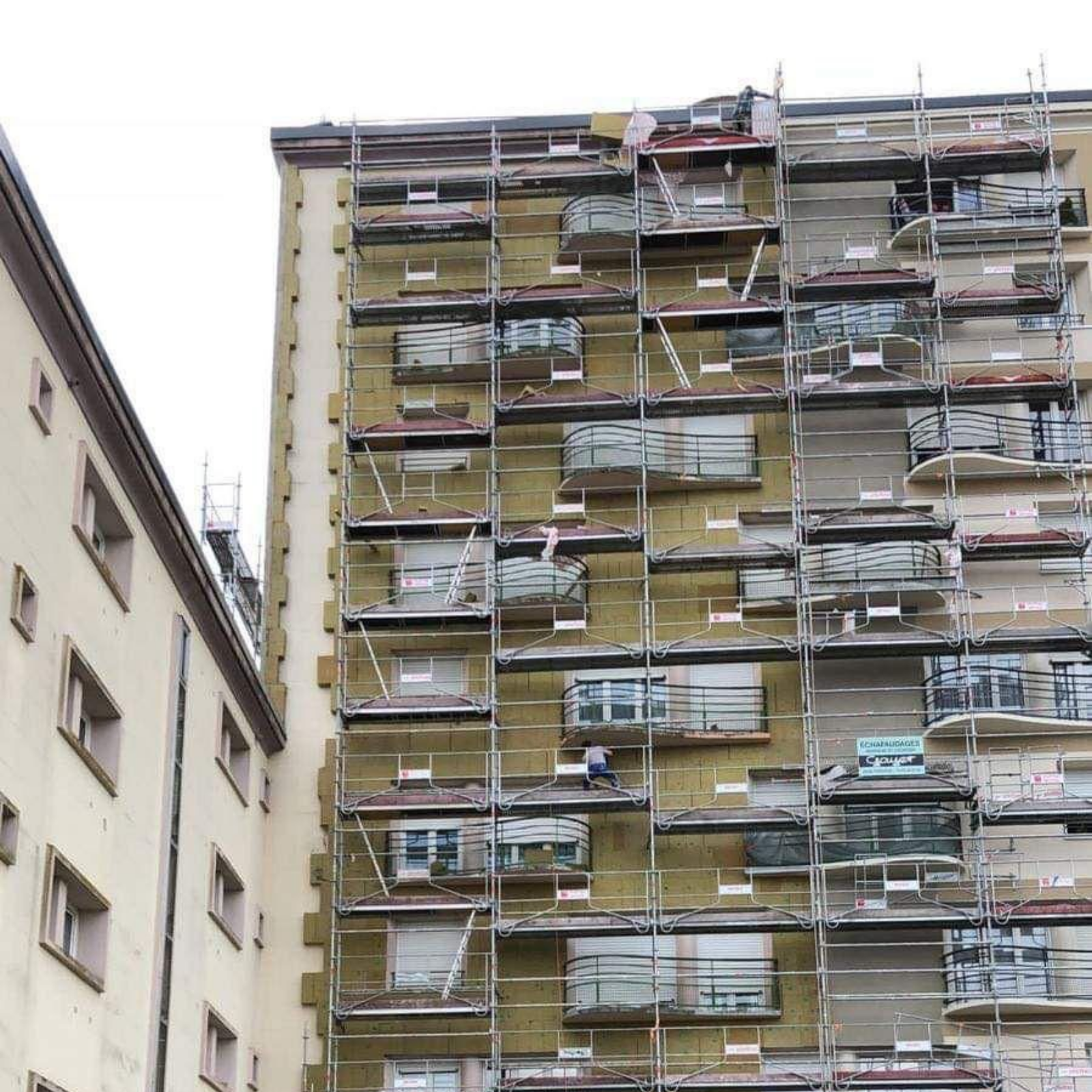 Échafaudages à l'extérieur du bâtiment, en construction, avec isolation.
