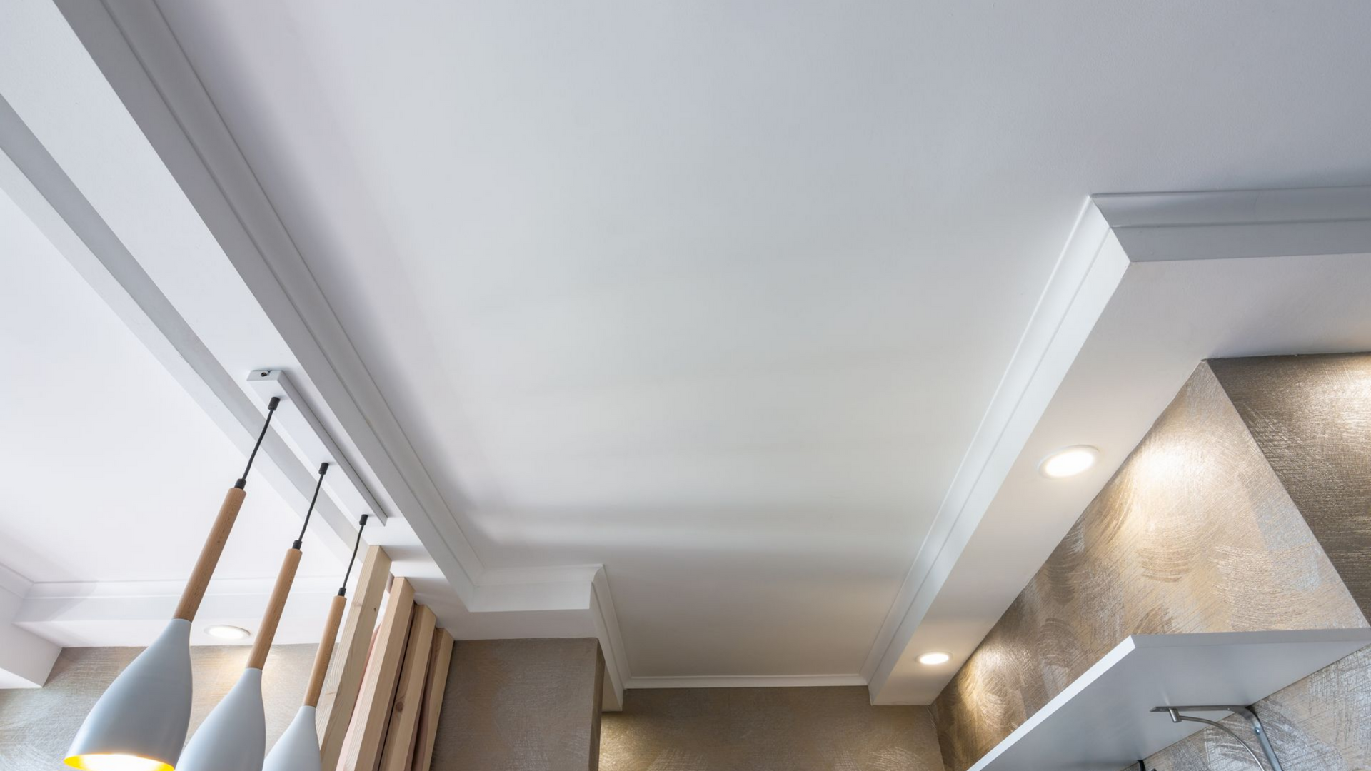 Plafond blanc orné de moulures .