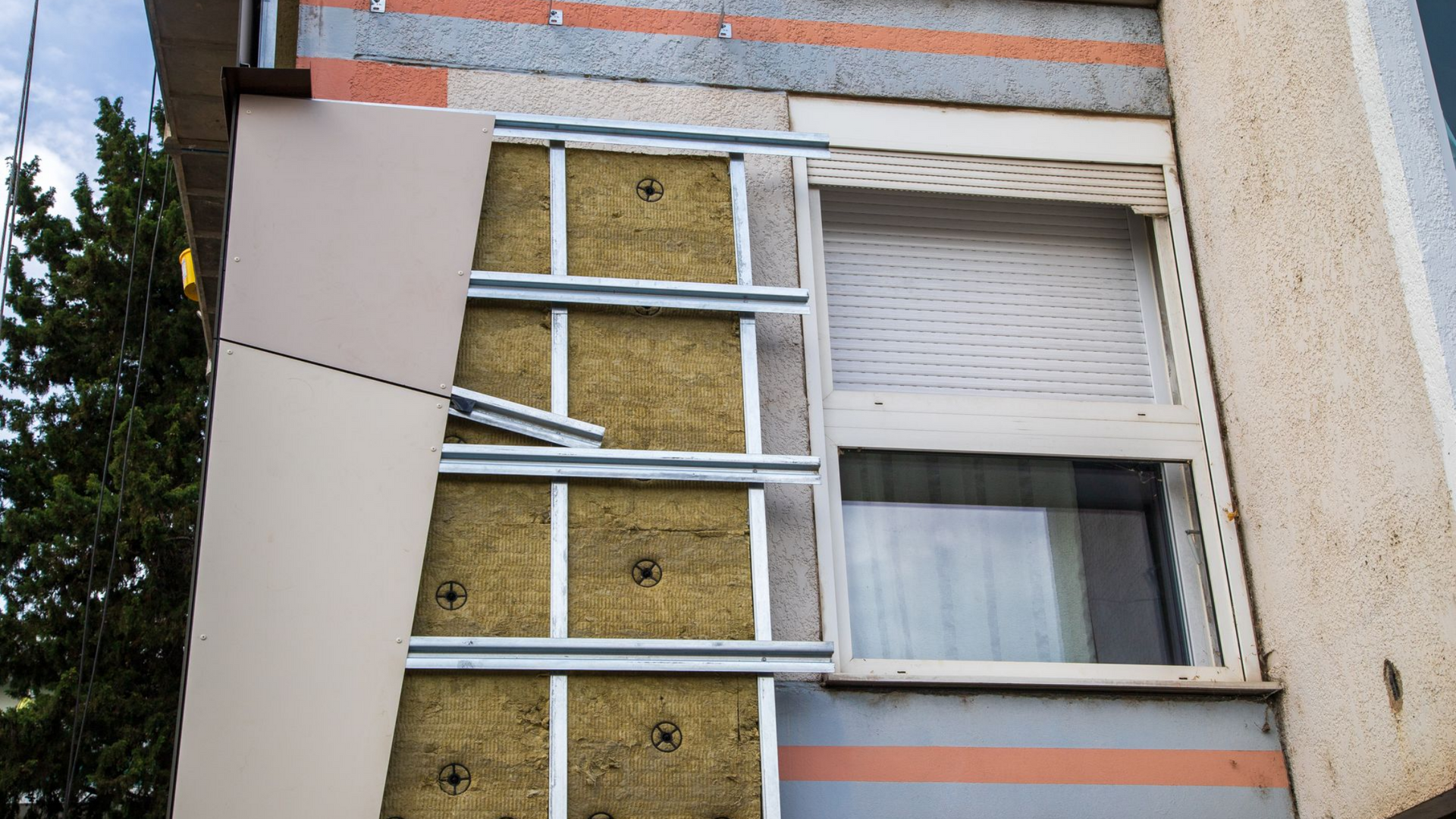 Mur extérieur en cours d'isolation avec ossature métallique et laine minérale.
