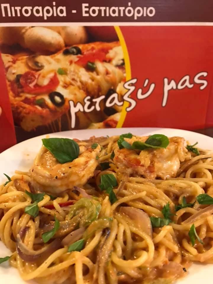 Greek restaurant ad with pasta, shrimp, and text “Το μετάξυ μας” on a red background