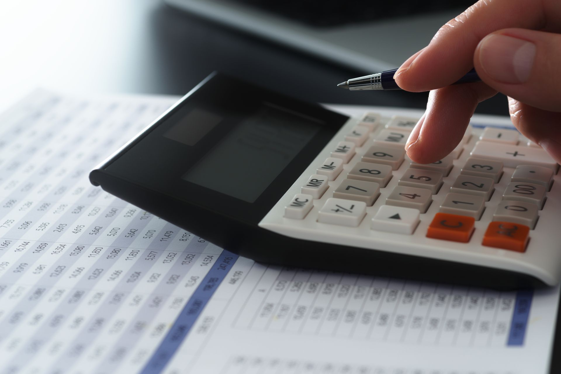 Un homme tape sur une calculatrice