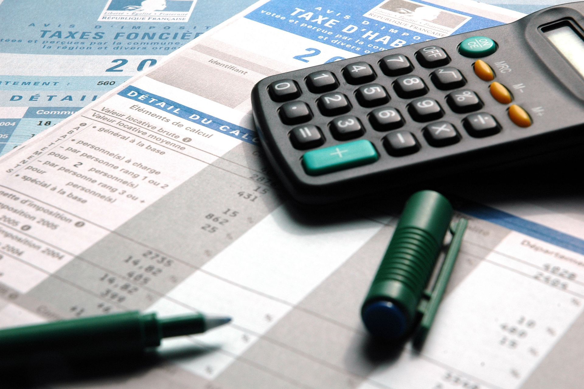 Stylo et calculette sur une feuille