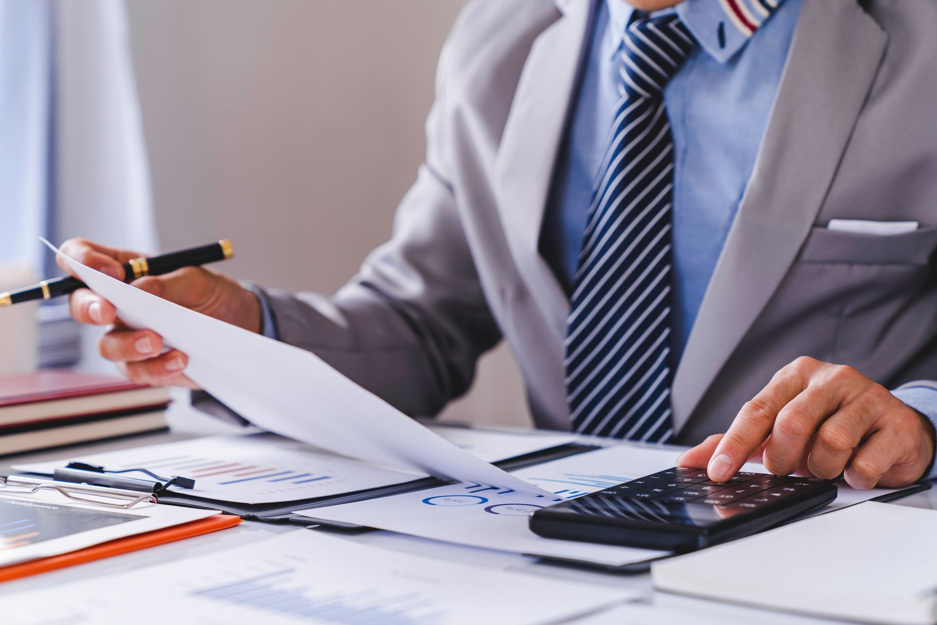 Un homme en costume utilise une calculatrice