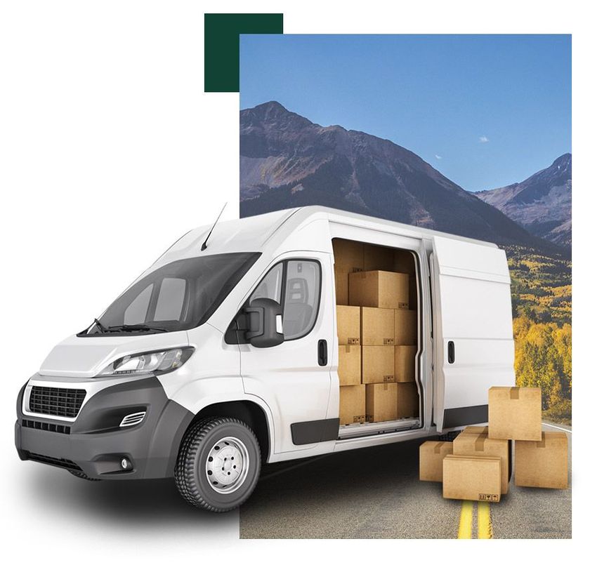 Una camioneta blanca con cajas en la parte trasera está estacionada al costado de la carretera.