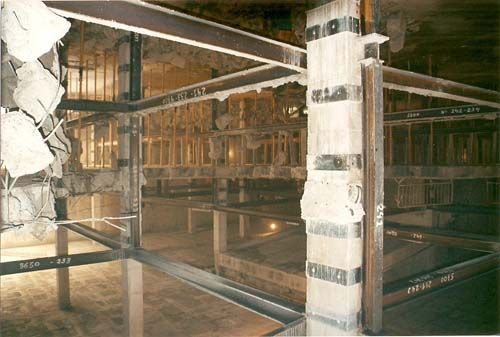Interior carbonizado con andamios metálicos y vigas expuestas en un edificio dañado.