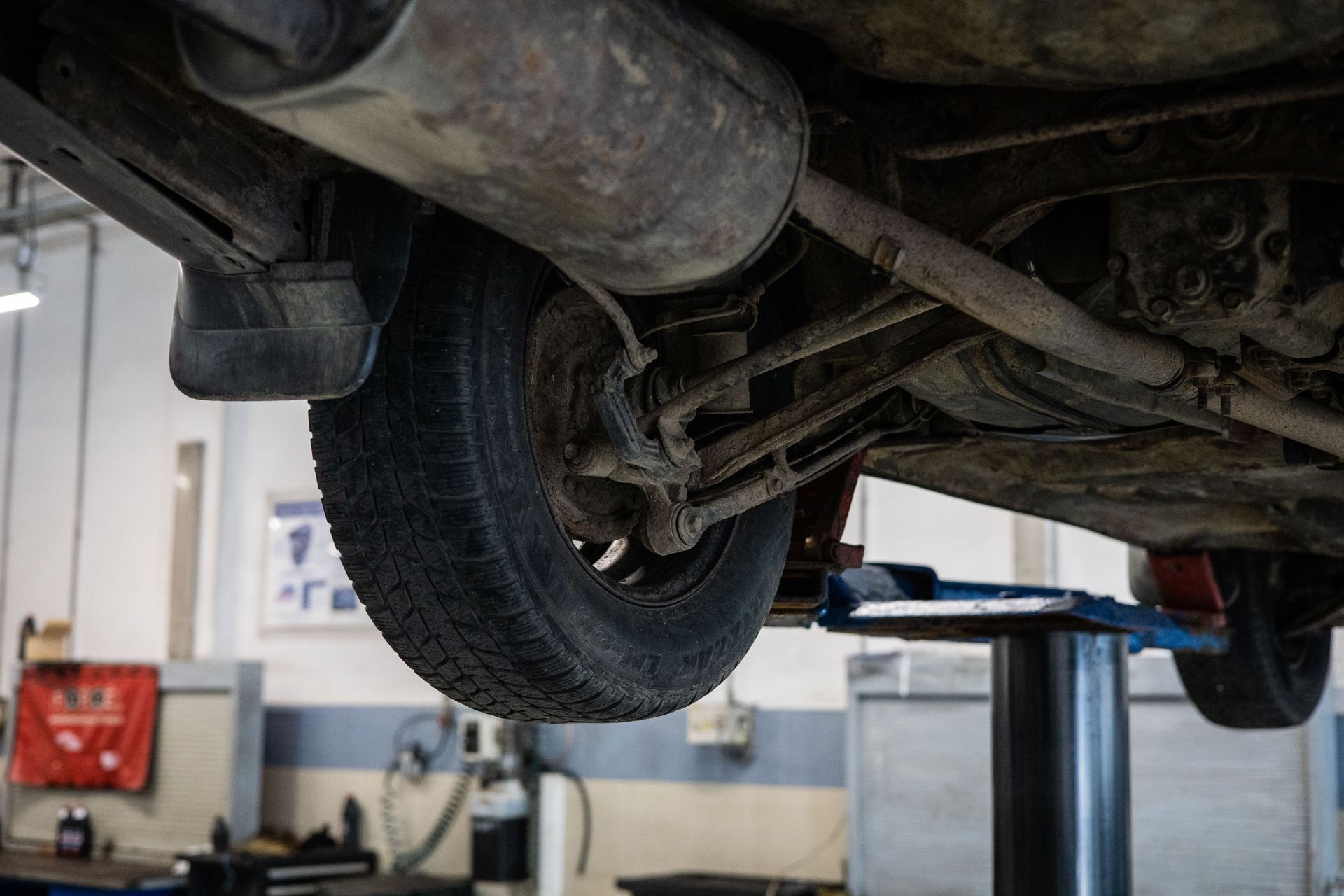 Parte inferior de un coche en un elevador en un taller de reparación de automóviles.