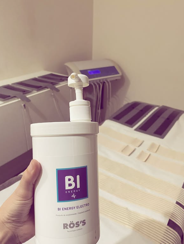 Una mano sostiene un frasco blanco con dosificador etiquetado como