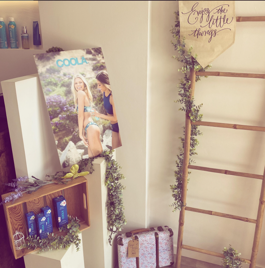 Pared decorada con un póster de una revista de moda, una guirnalda de oropel y un letrero que dice